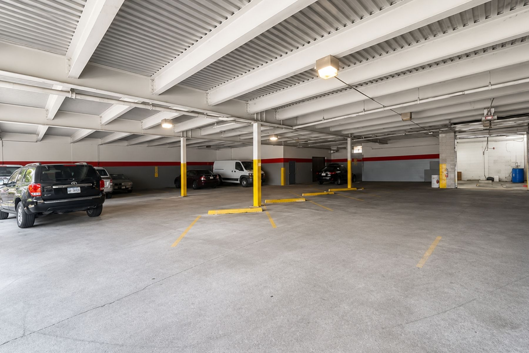 10,028 SF Garage Level Featuring a Drive-In Door, Wash Bay, and Covered Parking Spaces Commercial garage level showing a drive-in door, wash bay, and covered parking area.