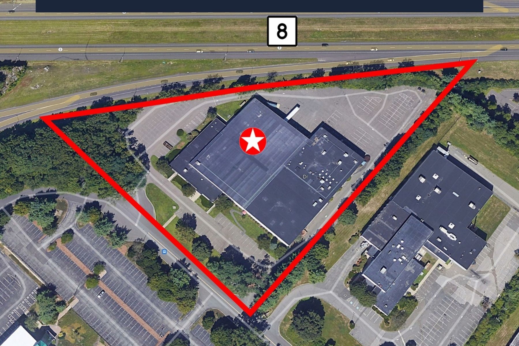 30 Nutmeg Drive Trumbull CT - Aerial Property Overview and Parking Lot High-angle aerial view of the commercial flex building and its expansive parking lot at 30 Nutmeg Drive in Trumbull, Connecticut, outlined in red to show property boundaries.