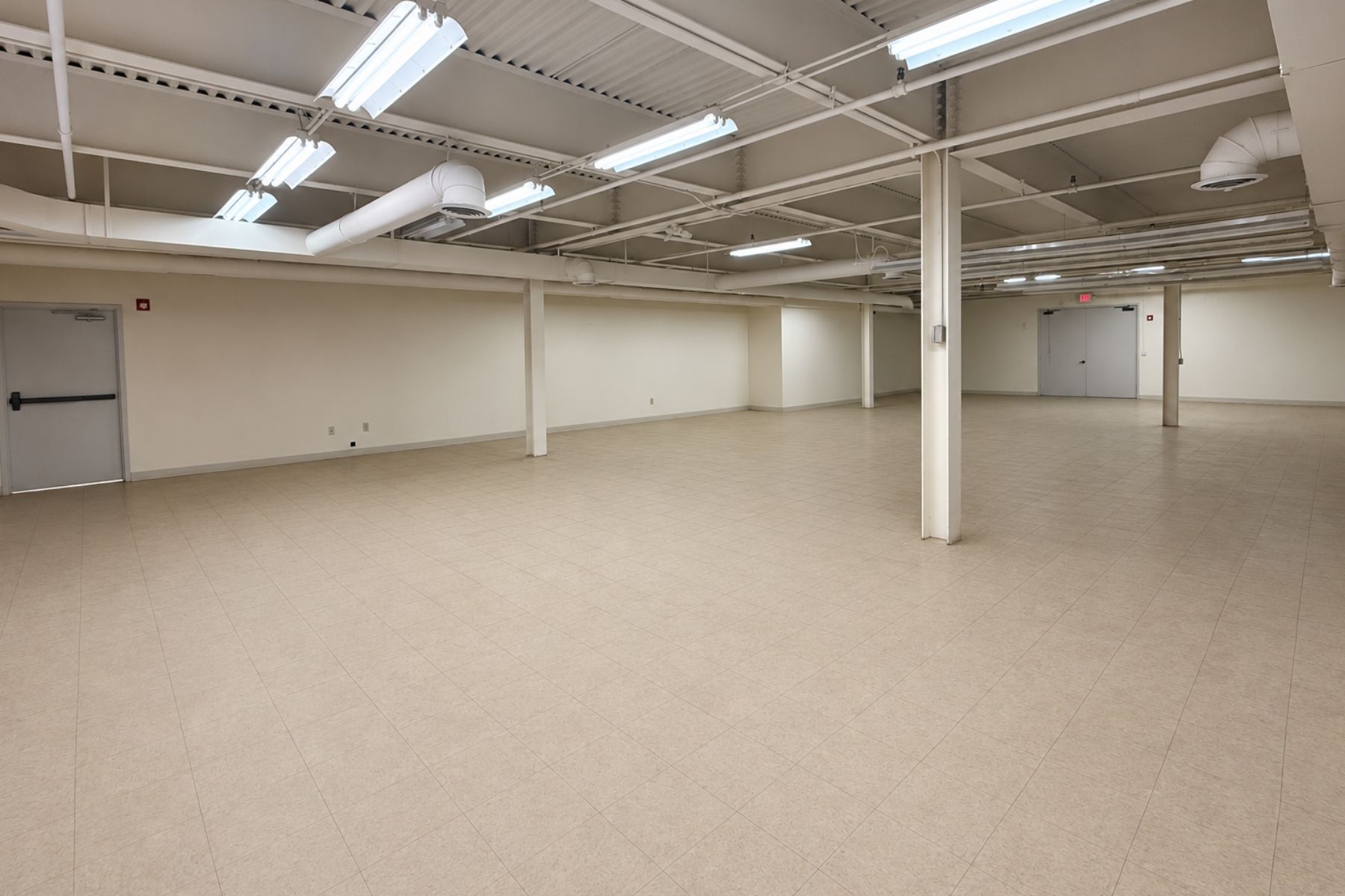 30 Nutmeg Drive Trumbull CT - Warehouse Interior and Ceiling Clearance Interior view of the open-concept warehouse space at 30 Nutmeg Drive in Trumbull, Connecticut, showcasing the concrete flooring, support columns, and a ceiling height of 10 feet 2 inches under the steel trusses.
