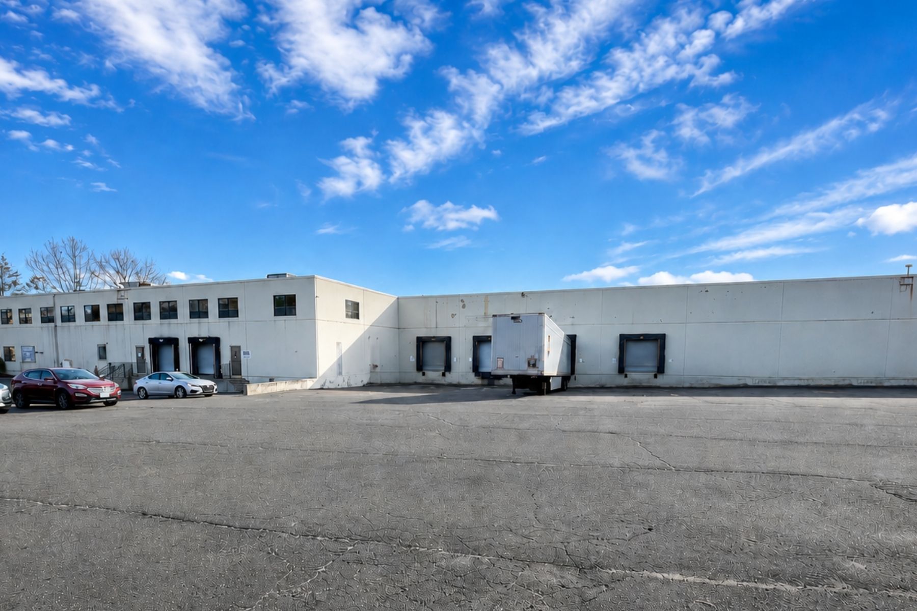 30 Nutmeg Drive Trumbull CT - Dedicated Loading Docks with Levelers Exterior view of the warehouse loading area at 30 Nutmeg Drive in Trumbull, Connecticut, highlighting the two dedicated loading docks equipped with levelers.
