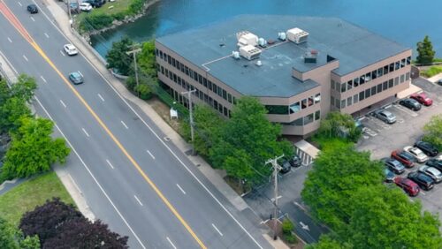 Aerial view of the One Post Road commercial office building in Fairfield, CT, highlighting its waterfront location on Ash Creek and direct access to the Post Road.