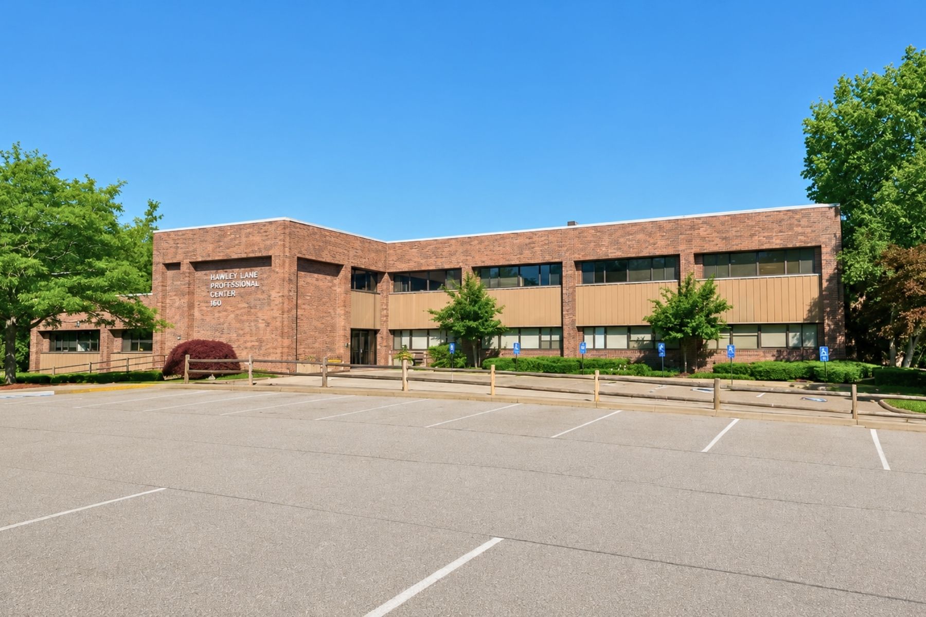 Prime SF Professional Medical _ Office Condominium Available at Crossroads of Merritt Parkway & Route 8 in Trumbull, CT Exterior brick facade of the Hawley Lane Professional Center medical office building and parking lot in Trumbull, CT