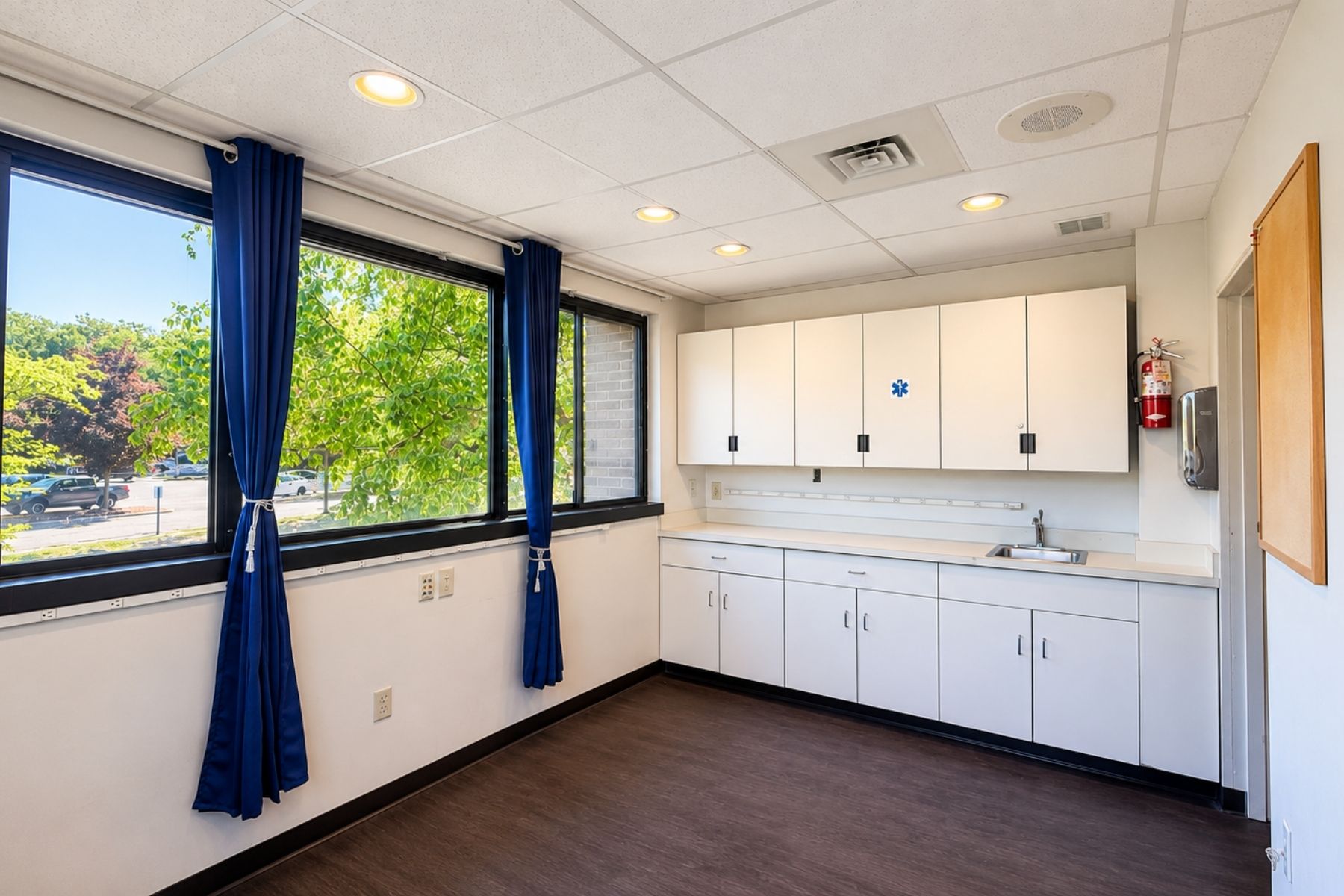 Breakroom with Cabinetry and Sink Interior view of a staff breakroom featuring custom cabinetry, countertops, a handwashing sink, and bright perimeter windows at Hawley Lane Professional Center in Trumbull, CT.