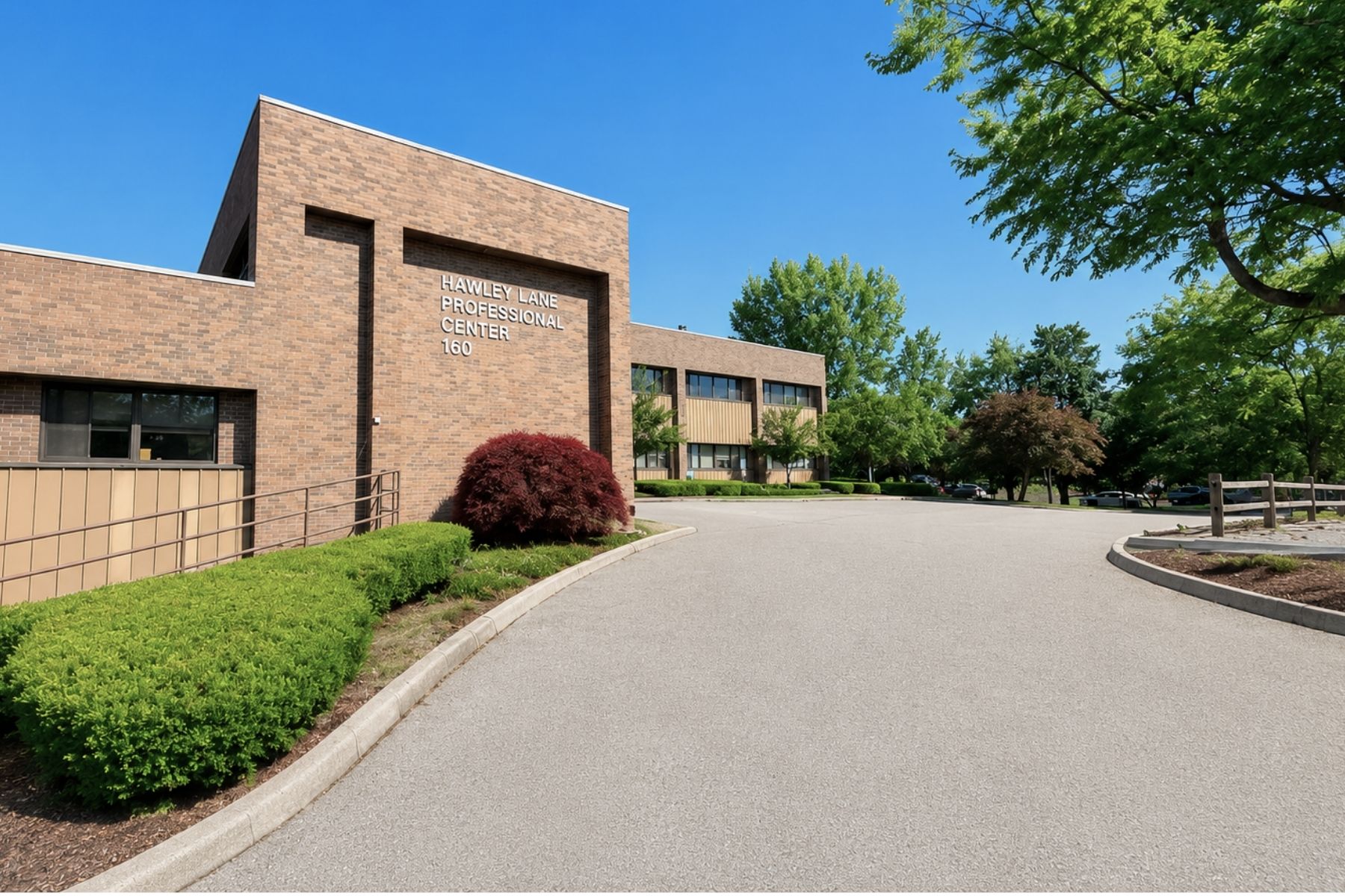 At the Hawley Lane Professional Center, a 35,867 SF Three-Story Medical Office Building Exterior view of the brick masonry entrance and paved driveway at Hawley Lane Professional Center in Trumbull, CT