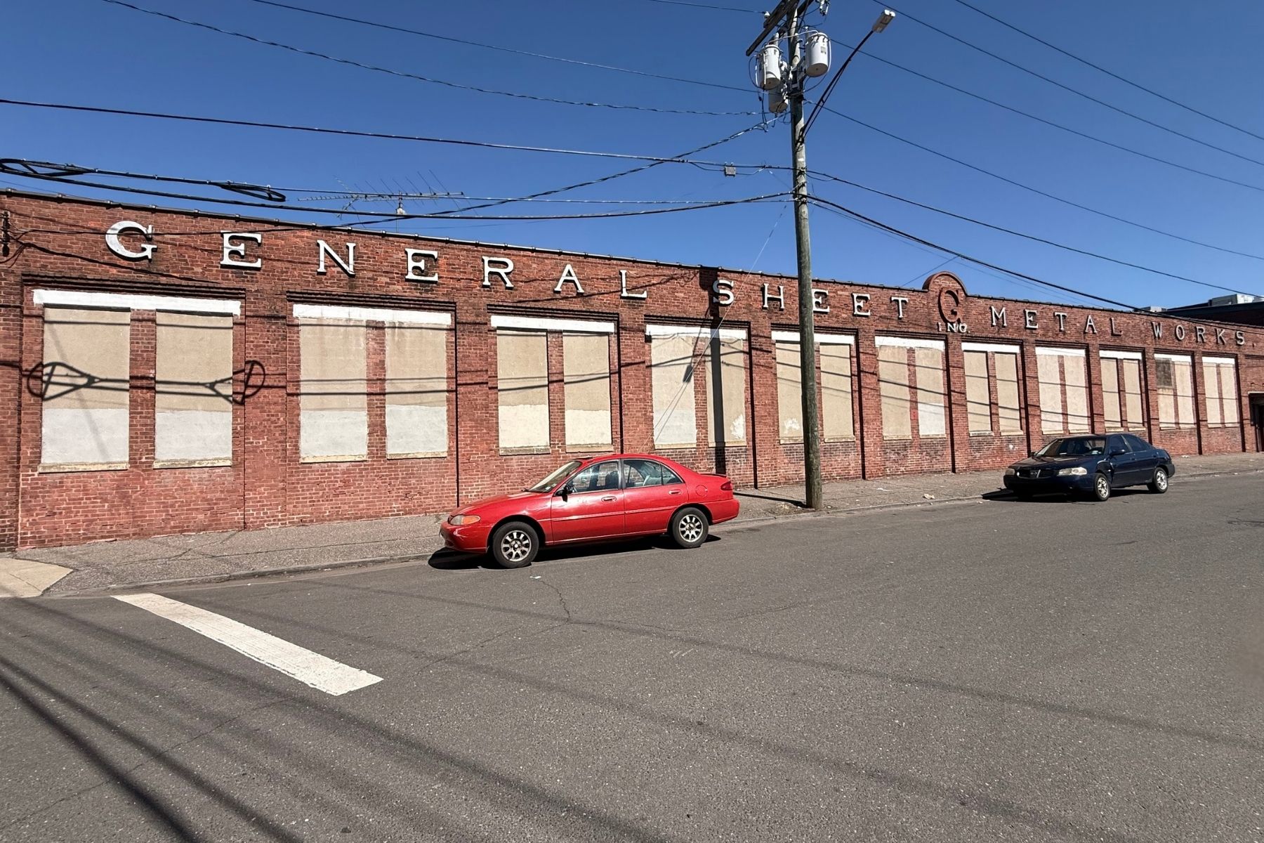 Industrial/Warehouse Property with 158' Frontage on Silliman Avenue Street-level view of the industrial property at 120 Silliman Avenue, Bridgeport, CT, highlighting the 158-foot road frontage and gated perimeter fence.