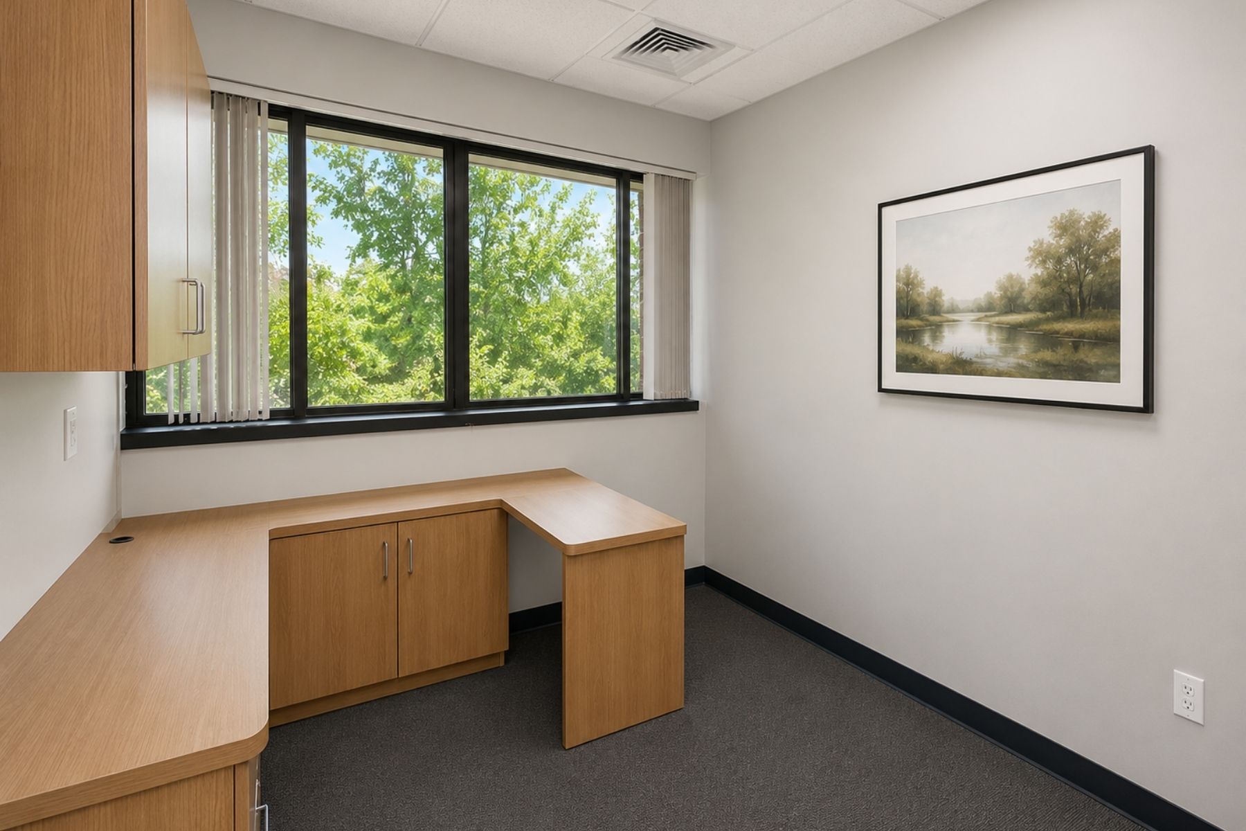 Bright Private Office with Built-in Desk & Wall-Unit Bright medical private office featuring a built-in L-shaped wooden desk, matching wall shelving unit, and a large perimeter window at Hawley Lane Professional Center in Trumbull, CT.
