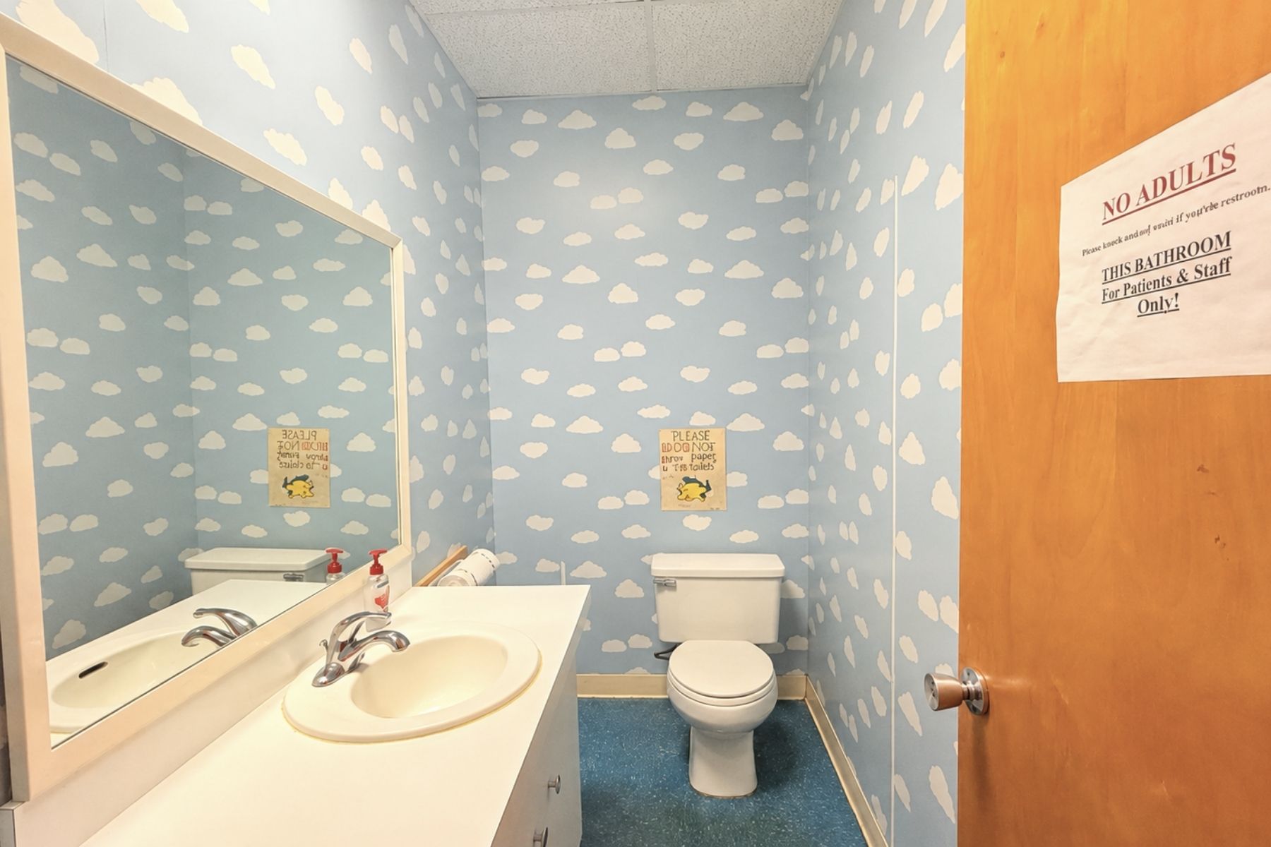 Private Restroom Modernized Private Restroom Featuring A White Toilet, Porcelain Sink, Vanity, And Wallpaper At Hawley Lane Professional Center In Trumbull, CT
